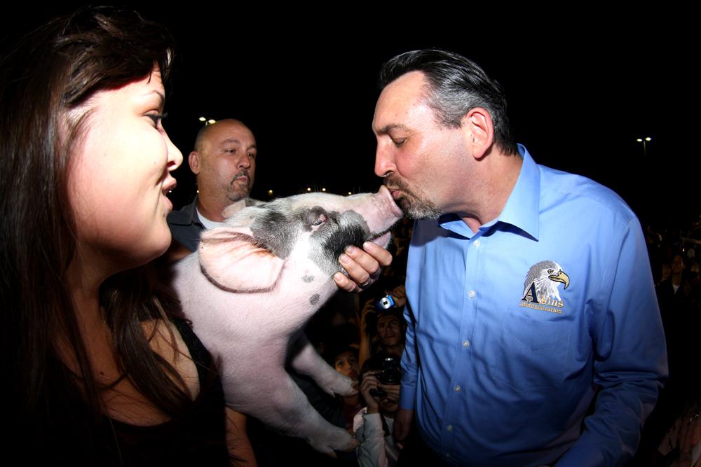 Principal Daniel Girard kisses a pig at Blue and Gold Night. He was the highest vote earner to kiss the pig. 