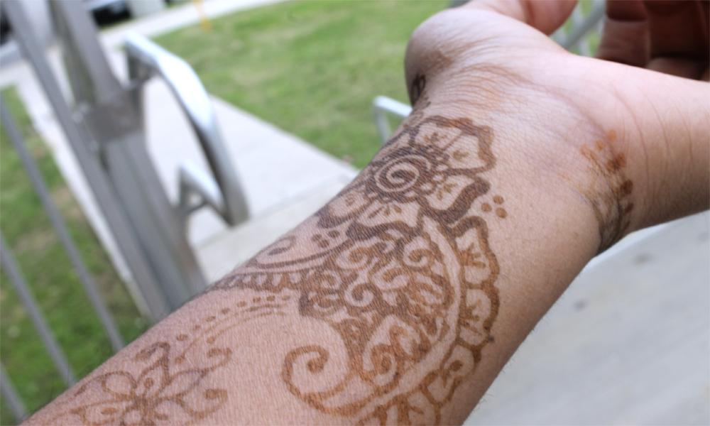 Lucia show her Henna done on her own arm for practice. Henna dries at short rates of time depending on the paste.