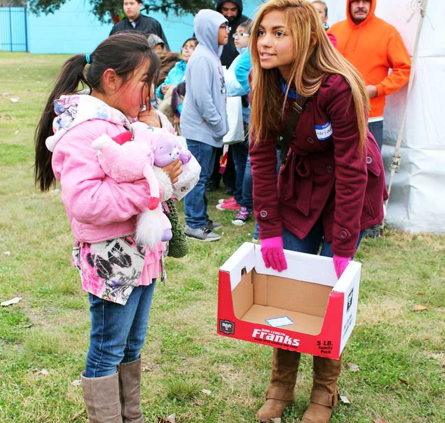 Senior Adrianna Moreno assists a girl with directions at the The River City Youth Foundation Annual Merry Memories. “It’s good for students to volunteer, because it makes you a more humble,and appreciative person,” Moreno said. Kids approached Akins Key Club volunteers all morning long to ask for directions or goodie bags. 