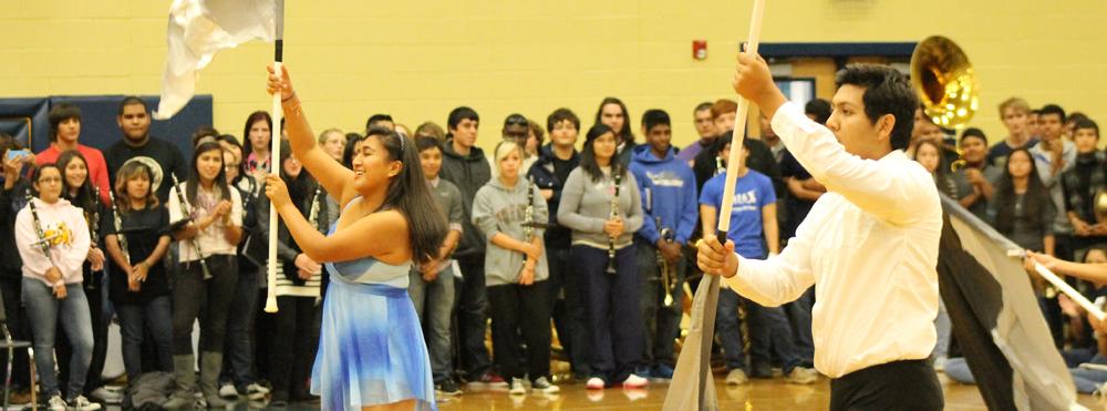 Senior Jobrinna Perez and junior Jorge Rocha preforms during the pep rally for the play offs, twirling their flags in a routine fashion. Perez has been in color guard since her freshman year and is one of the only 6 color guard members. The guard is working with the band directors to grow the team to at least 30 members.