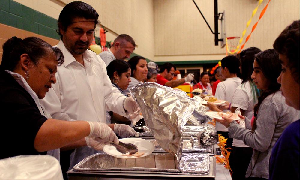 Volunteers serve families a thanksgiving meal at the Dove Springs Recreation Center. Students from the Correctional Student Internship volunteered to help.
