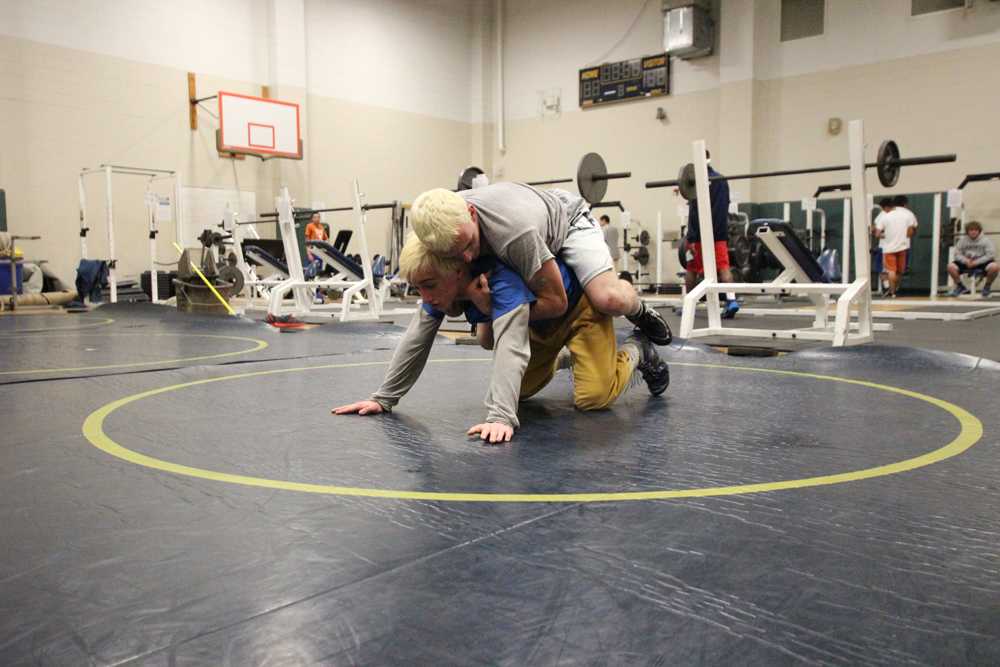 Alex helps Austin build up his strength during wrestling practice by adding weight while Austin bearcrawls across the wrestling mats. “I constantly have to push myself on and off the mat and even in the class room,” Austin said. Austin and Alex both depend on each other to push one another. 