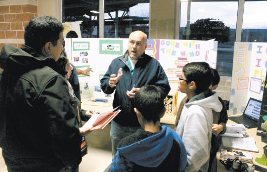 ACES teacher Eric John explains Green Tech’s programs to families. Green Tech was introduced at the annual Academy Fair last week.