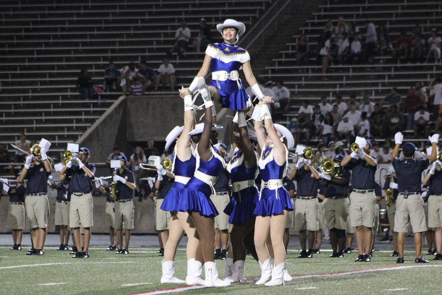 Diamond Dazzlers lift junior Jessica Salinas into a stunt. The dance team has worked hard to try new things and be more organized.