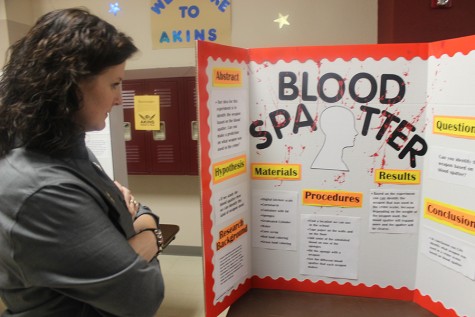 Principal Hosack inspects a students science fair project. 