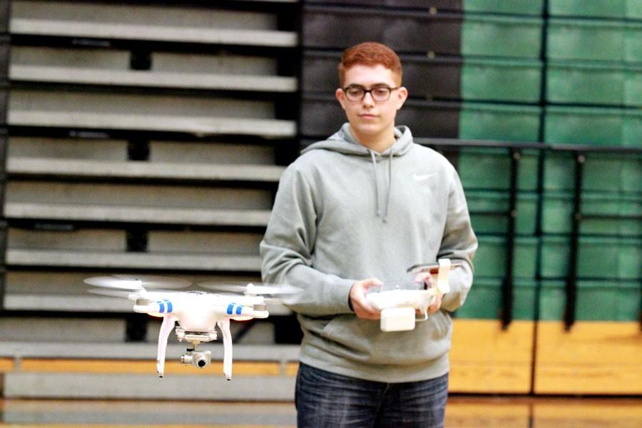 Junior+Zach+Trevino+demonstrates+the+drones+flying+capabilities+in+the+gym+for+aerospace+students.