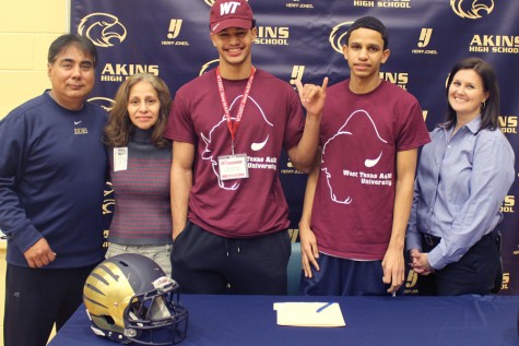 Senior Omar Bailey shows his school spirit after signing his letter of intent with West Texas A&M University. On the far left is Football Coach Humberto Garza and Bailey’s mom. On the far right is Interm Principal Brandi Hosack and Bailey’s brother.