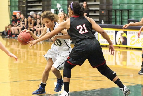 Junior Brooklyn Childers goes in to shoot while being defended by Bowie High School players. Akins lost 68 to 38 that night