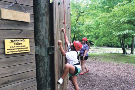 Left: Akins students and Young Life leaders at Young Life camp last summer. The camp is called Sharptop Cove and it is in Jasper, Georgia. Right: Junior Marina Godinez at Young Life camp last summer climbing the rock wall.