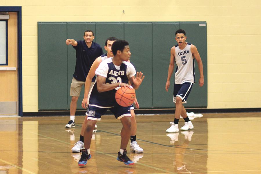 Sophomore Laryy Durden with the ball tests the skill of his fellow teammates with a quick practice play. The boys basketball team readys themselves during preseason.