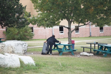 A custodian picks up garbage left by students after lunch
in the courtyard.