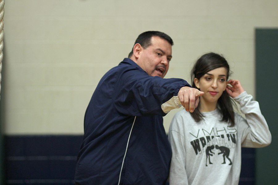 Head wrestling Coach Roy Tambunga gives advice to sophomore Leila Levens. Tambunga, who has coached for 20 years, has successfully guided wrestlers
to state championship titles. Akins wrestlers have also won district championships from 2012, 2013, 2014 and 2015.