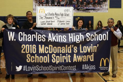 McDonalds Restaurant owners present  Akins Principal Brandi Hosack with a check for $10,000 on Thursday in the campus gym. The money was awarded after Akins won first place in a social media school spirit contest that took place this fall.