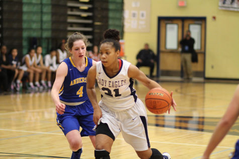 Captain and point guard Denae Lofton advances through her Anderson opponent in a district game.