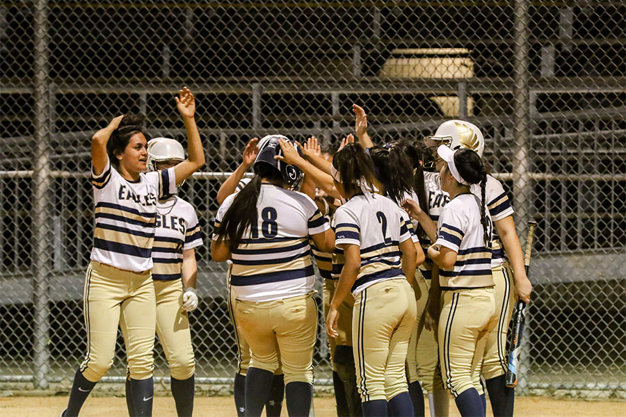 Varsity+Softball+celebrates+team+member+Sabrina+Lopez+on+her+home+run+against+Manor+on+April+4.