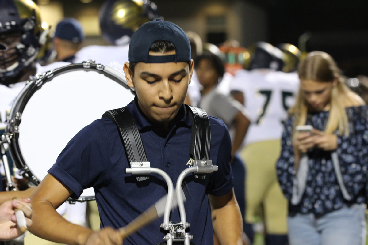 Junior Marcus Alvarado performs for the student section at the game alongside the drumline during the September 21st game against McCallum.