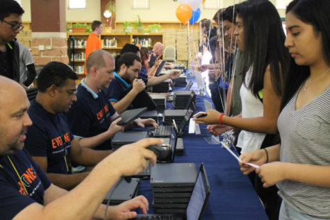 Austin ISD tech support staff and volunteers help distribute laptops to Akins students on Aug. 29 in the library. The initiative provided every student with a Chromebook that they will keep until the end of their high school career.