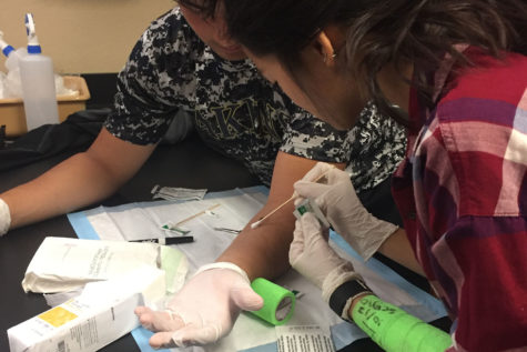 Biomed students Sergio Ambriz and Jennifer
Quach practice treating and cleaning wounds