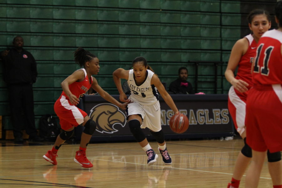 Denae Lofton goes for a 2 point play after
crossing over a Del Valle player, Jan. 31st in the Akins gym.