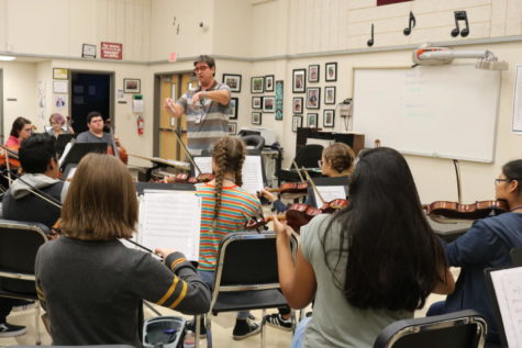 Orchestra director Thomas Mann leads his symphonic orchestra. Mann said that he was interested in increasing communication of  fine arts programs.