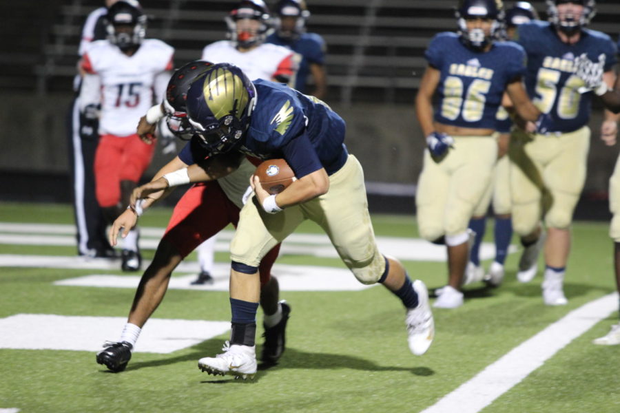 Senior Nicholas Cagle runs past a Del Valle Cardinal to get his third rushing touchdown of the game, helping him get closer to breaking a school record for the most single-season touchdowns by a quarterback. This season he scored 11 such touchdowns.