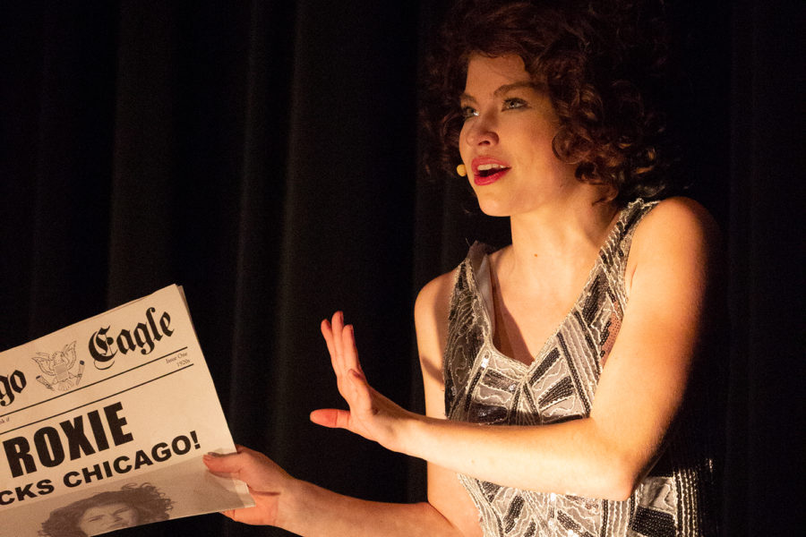 Roxie Hart (played by Kacey Wasson) speaks on her appearance in the newspaper.