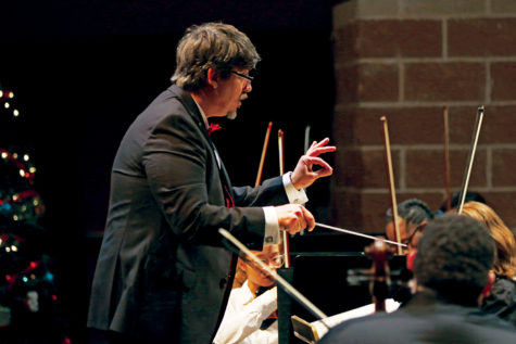 Orchestra director Thomas Mann leads the orchestra during their winter concert. Mann wrote seven pieces over the course of his gradu- ate course to get his masters, including a piece for the Akins orchestra to perform.