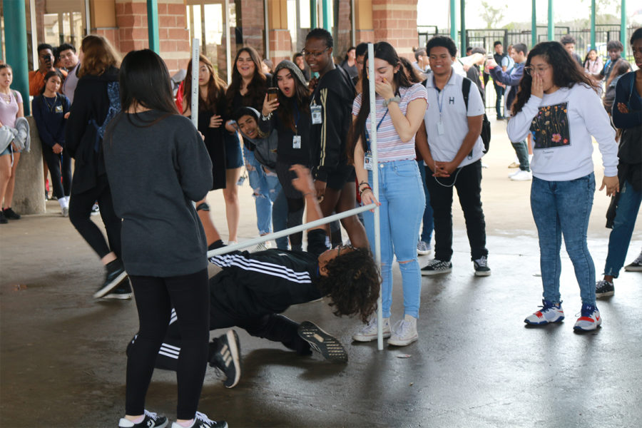 Junior Isaiah Sibi-Hackney participates in a limbo contest sponsored by Key Club  during lunch outside of the cafeteria. The contest is designed to promote the Akins-Thon fundraiser event.