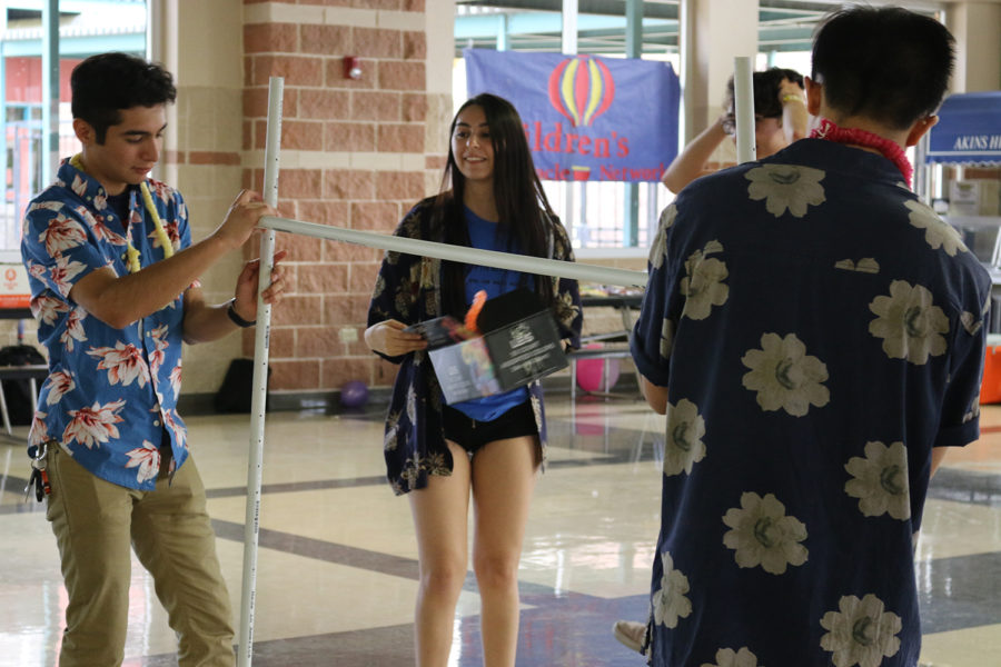 Students (akinsTHON members) set up limbo station for an afternoon of fun in the cafeteria.