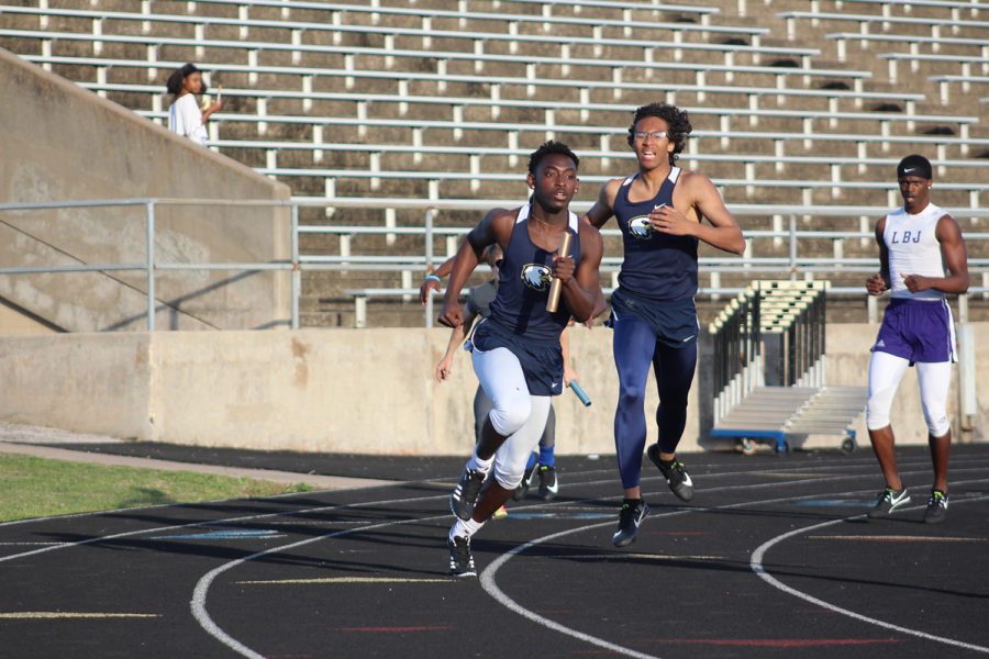 Senior Alpha Mara takes the baton from Isaiah Sibi Hackney to finish and take 1st place in the South Austin Relays. Varsity boys took 3rd place in their district at the meet.