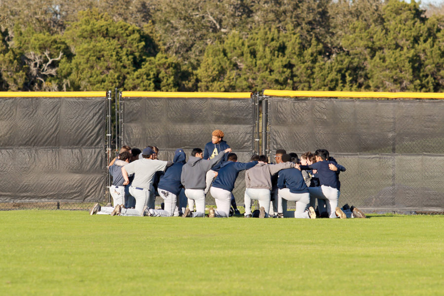 Senior+Julian+Smith+gives+the+team+a+pre-game+pep-talk.+The+team+also+says+a+prayer+to+boost+morale.