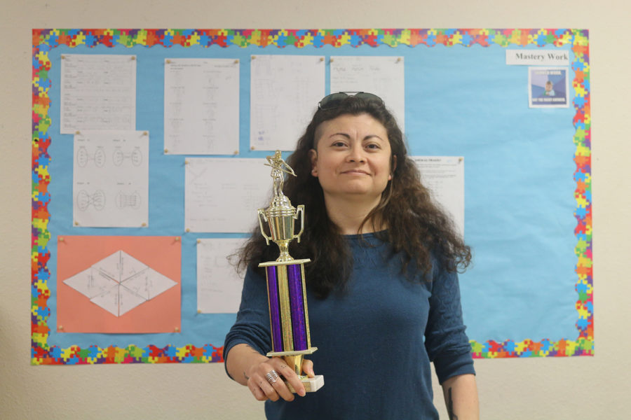 Math teacher Elise Briseno holds her APA TriCup quali cation round billiards trophy. When she isn’t at school, she plays professional pool.