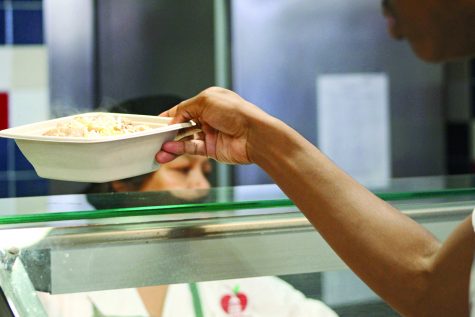 A student picks up a  esta bowl in the Akins cafeteria on Sept. 24. Fiesta bowls are one of the most popular items that the cafeteria serves, which includes organic meats, rice and beans.