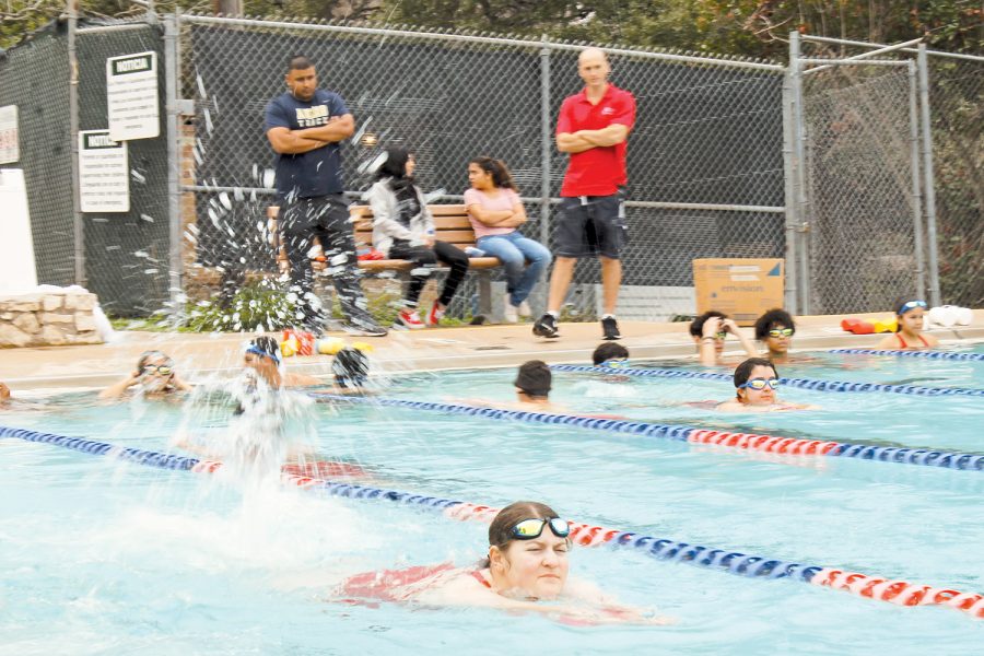 Coach Jerry De La Huerta conducts and observes swim practice. For some students this is their  first time learning to swim.