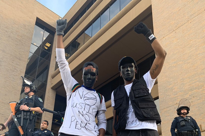 Anthony Evans (left) protests with his twin brother Arthur Evans (right) at the Austin Police Department on May 31 before he was shot with a rubber bullet in his face, causing a severe injury to his jaw.
