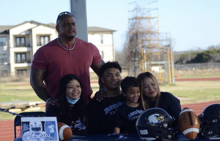 Trystin Brown, officially official!- 
Trystin Brown smiles at the camera after his signing to play college football for the Blinn College Buccaneers. He played the position free safety and wide receiver for the Akins Eagles football team. His mother (far-right), brother (middle-right), sister (middle left) and father (top-left) accompanied him during his signing on Feb. 3.