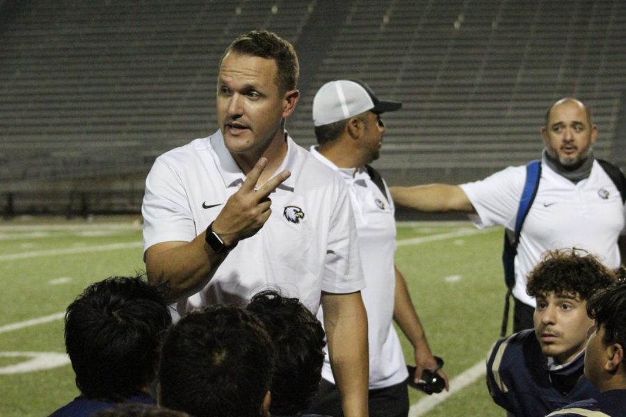 Coach Joey Saxe talks to players after Homecoming win against the Austin High Maroons