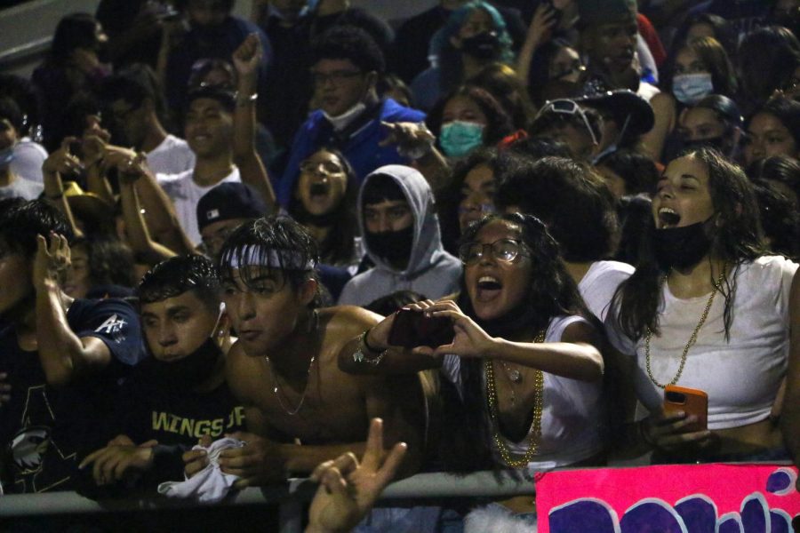 Students show their support by cheering on the football players during the Homecoming Game.