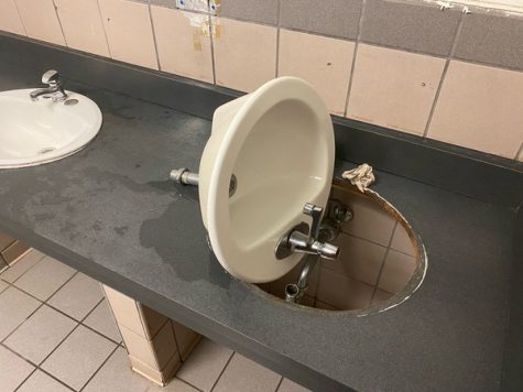 A detached sink lies on the counter in a boys bathroom after being disconnected in an effort to damage the bathroom as part of the Devious Lick trend that spread on TikTok.