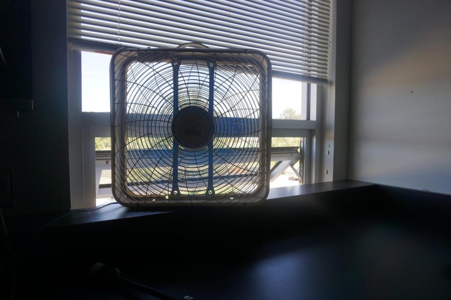 A+box+fan+blows+in+air+from+an+open+window+Christopher+Orfs+classroom.+Amid+air+conditioner+failures%2C+many+teachers+have+resorted+to+using+portable+fans+to+keep+themselves+and+their+students+cool+in+all+of+the+heat.