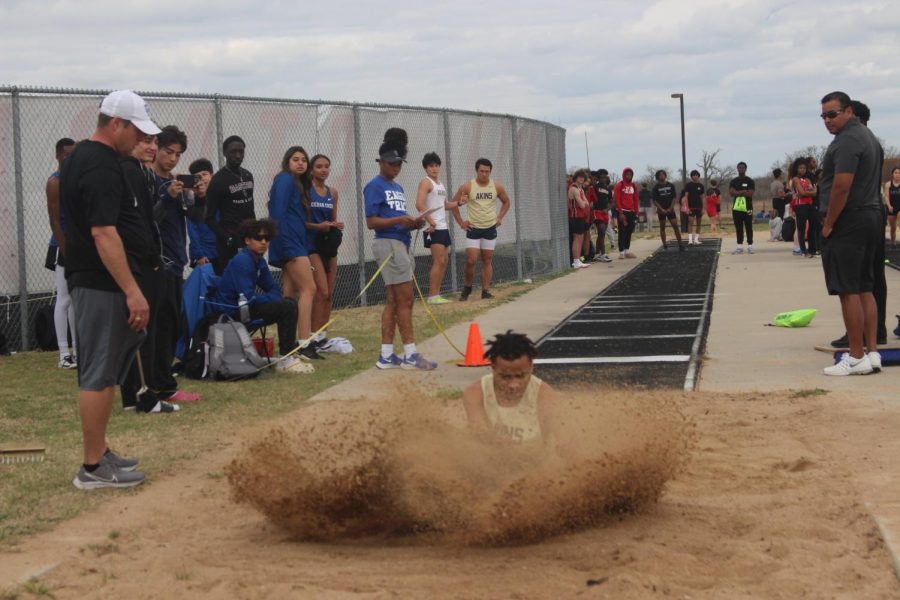 Senior Davion Smith lands after taking his attempt at the long jump at the Cedar Ridge Relays track meet.