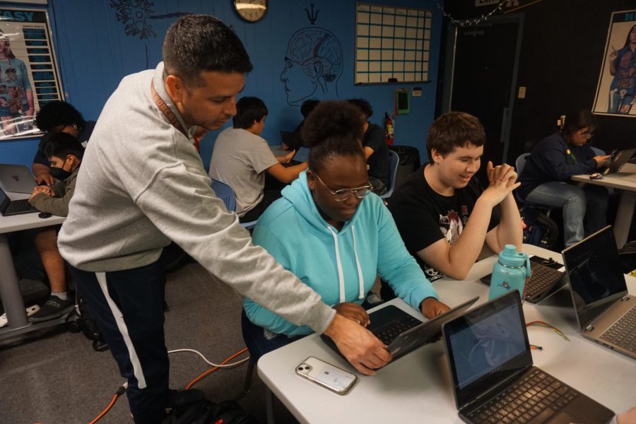 Health teacher Francisco Flores helps a student do their work in class.