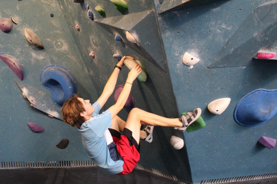 Junior Renzo Montgomery climbs the wall at Crux as part of the Akins Rock Cllimbing Club, which started this year.