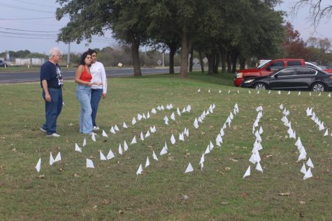 Students Crystal Castillo and Kayla Zamora-Nuñez place 392 white flags at the front of the school to create a memorial representing the lives lost to school shootings since the 1999 Columbine shooting.