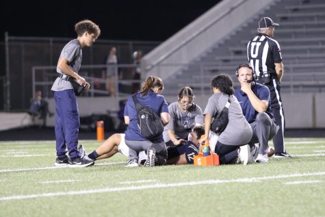 Athletic Trainer Ann-Marie Reynolds and sports medicine students Assist Junior Matthew Ybarra during the Akins West Lake Football game on September 9, 2022 .