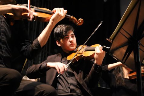 Junior Pedro Salas concentrating playing the violin with the Austin Symphony Orchestra.
