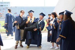 Members of Akins Class of 2023 celebrate before walking the graduation stage at Burger Stadium on May 31.