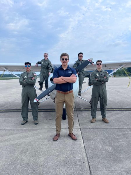 Senior Hector Hernandez, on the left , strikes a pose with his fellow sa-dets behind thier pilot instructor with a plane.