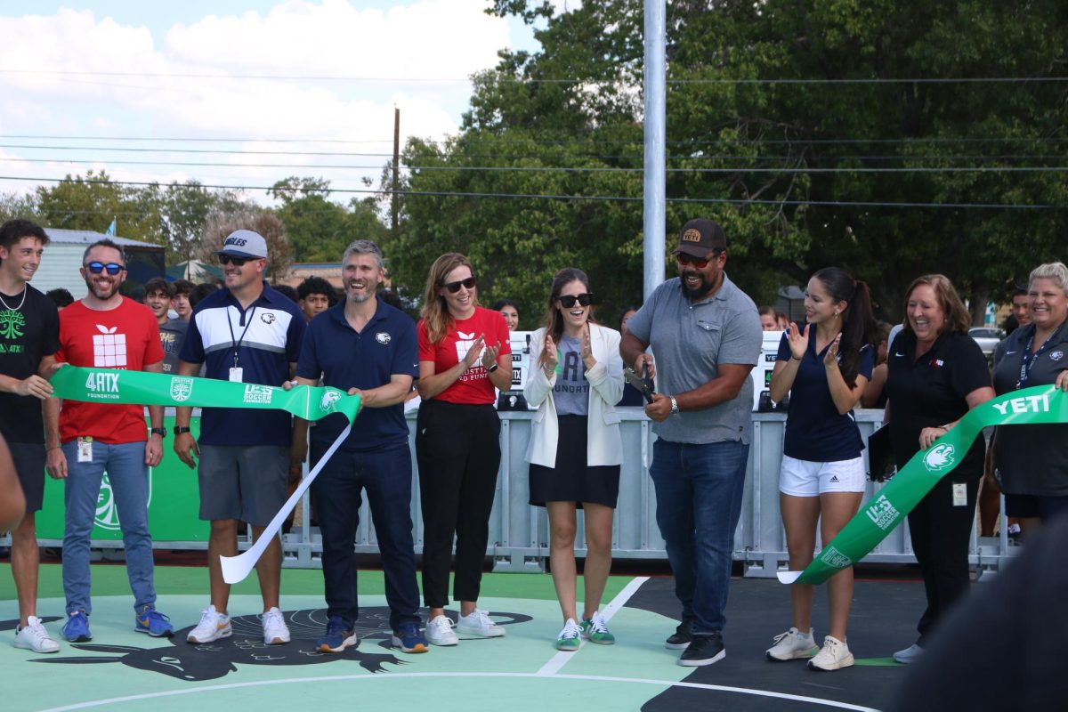 A representative from Yeti, a financial sponsor of the project, cuts the ribbon on Sept. 29 to officially open the mini-pitch that was added to the Akins tennis courts. The mini-pitch allows the Akins community to play games of soccer with smaller teams on a hard court surface.