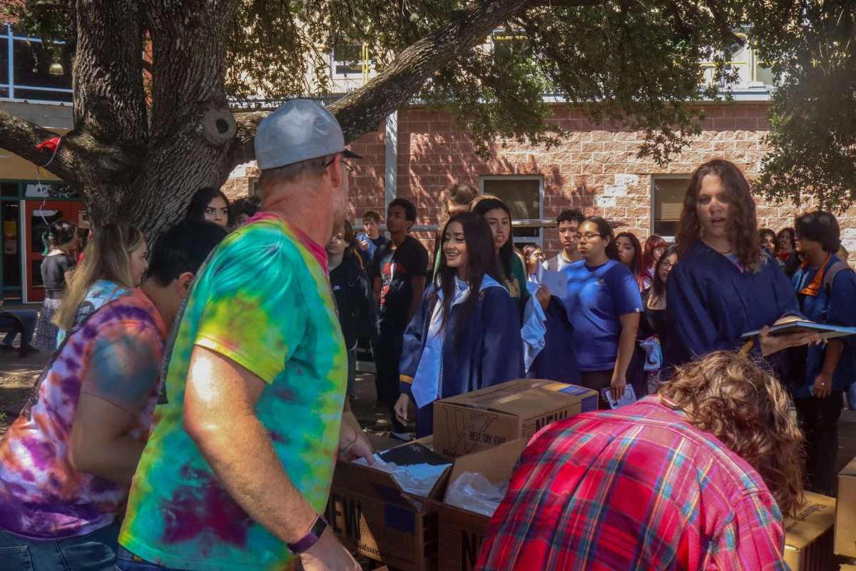 Akins yearbook teacher and staff giving seniors their yearbook